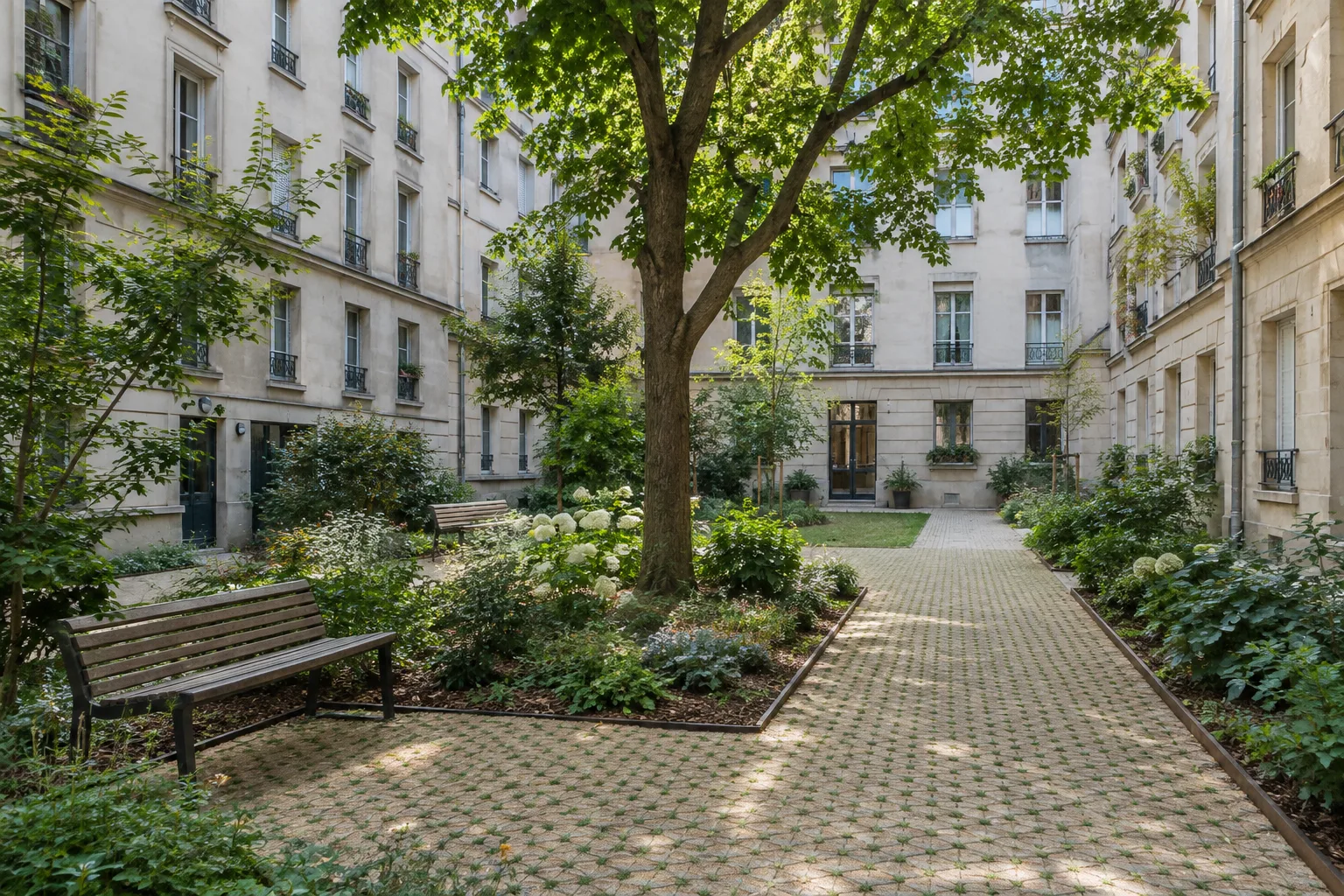 Cour d’immeuble réhabilitée avec des plantations, des bancs et un cheminement dégagé.